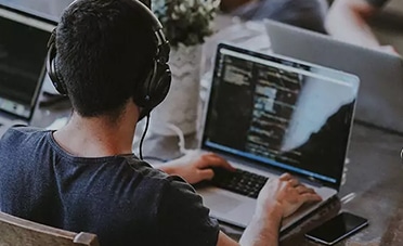 A group of interns working at a table on their laptops.