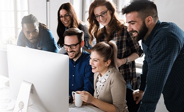 A group of people learning how to build a proactive recruiting strategy while looking at a computer screen.