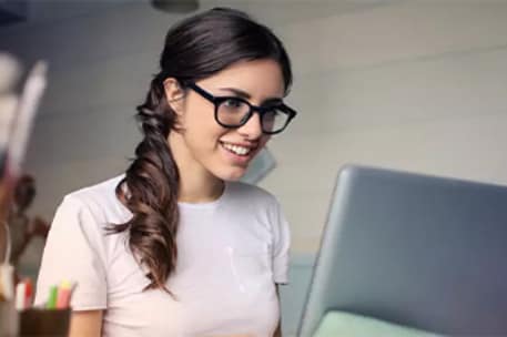 Job Description Template for Full-Time Employee: A woman using a laptop.