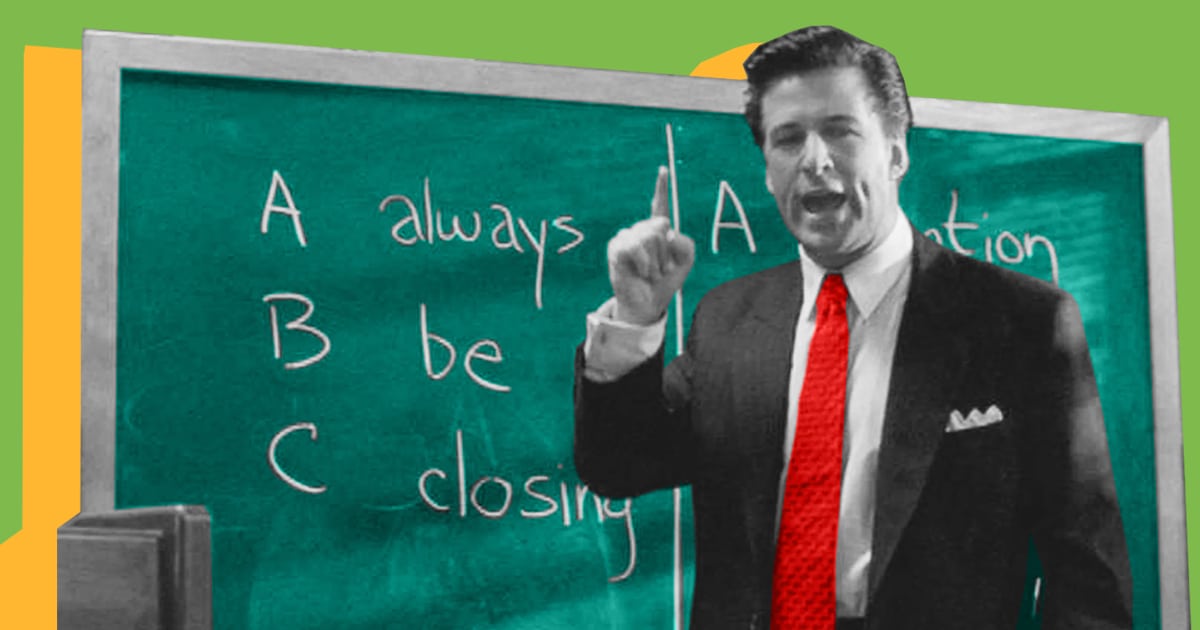 A professional man poses in front of a blackboard.