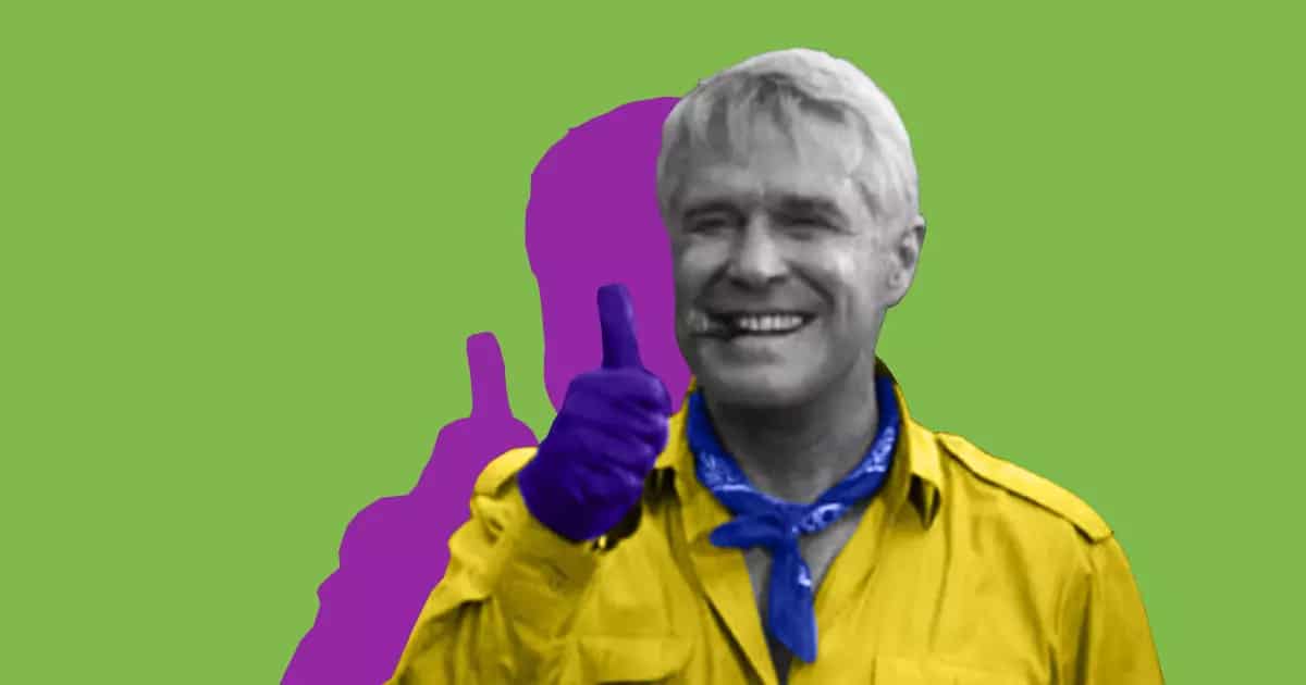 A man in a yellow shirt demonstrating approval with a thumbs up gesture.