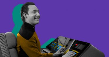 An individual in a Star Trek uniform engages with a computer screen.