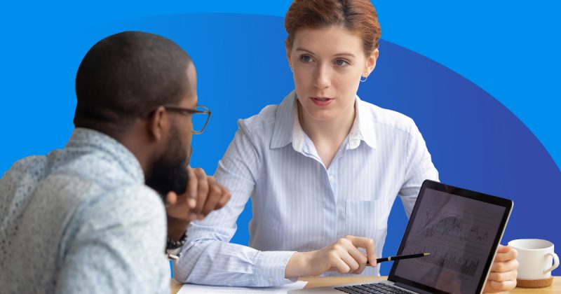 Two individuals engaged in candidate evaluation at a table with a laptop.